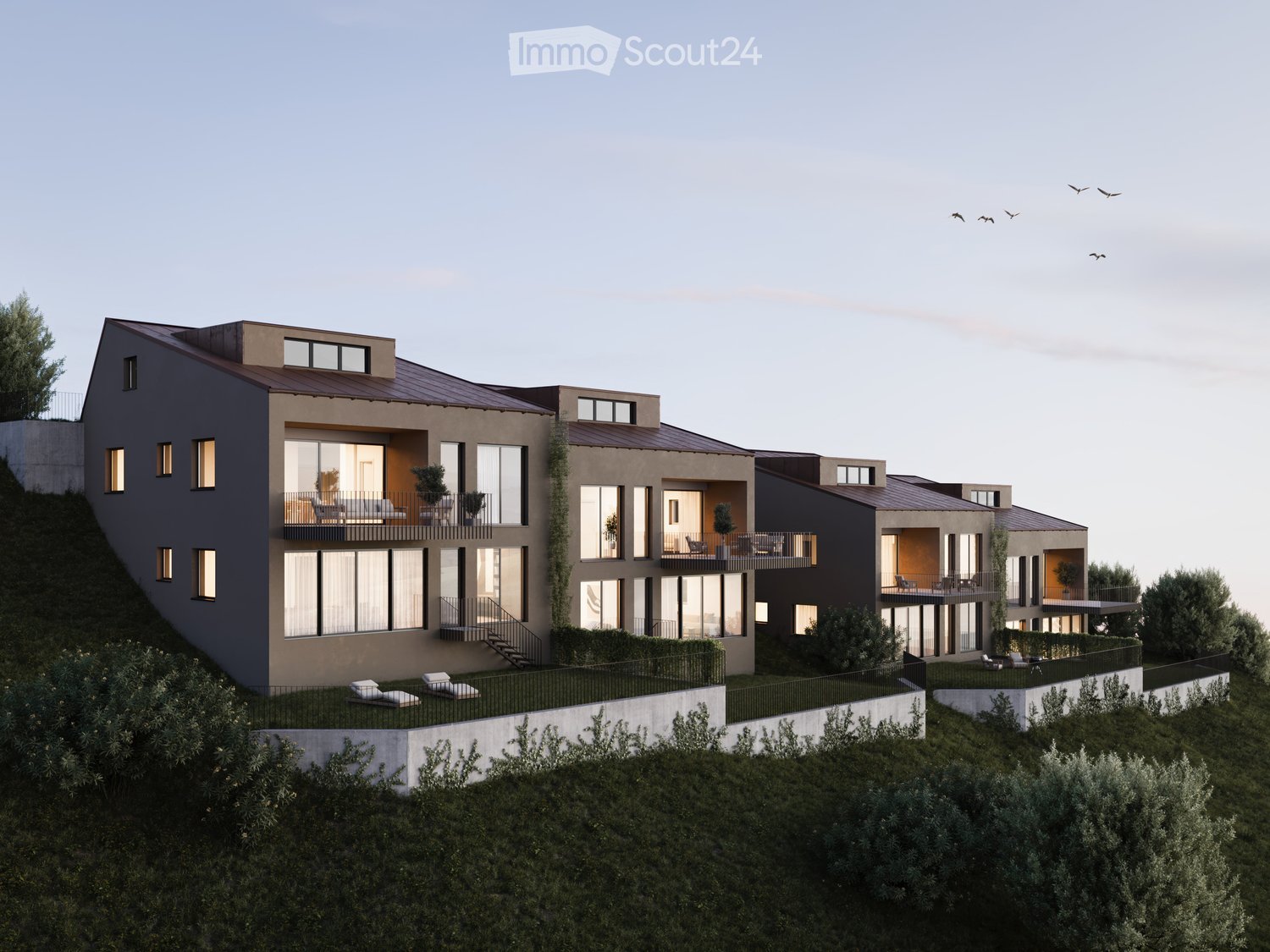 A modern multi-story apartment building with dark exterior walls, large windows, and balconies overlooking a landscaped area with trees. The building has a sleek, contemporary design with a mix of materials and architectural elements.