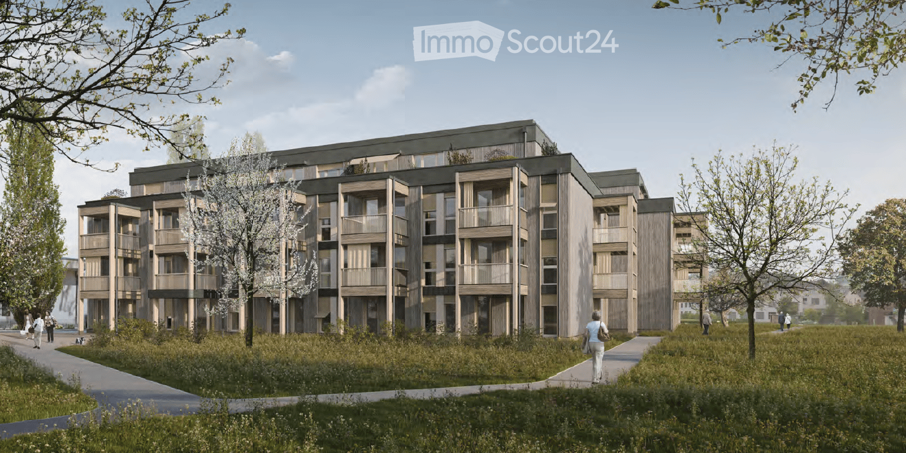 Multi-story apartment building with balconies, surrounded by trees and greenery, with people walking on the path in front of the building