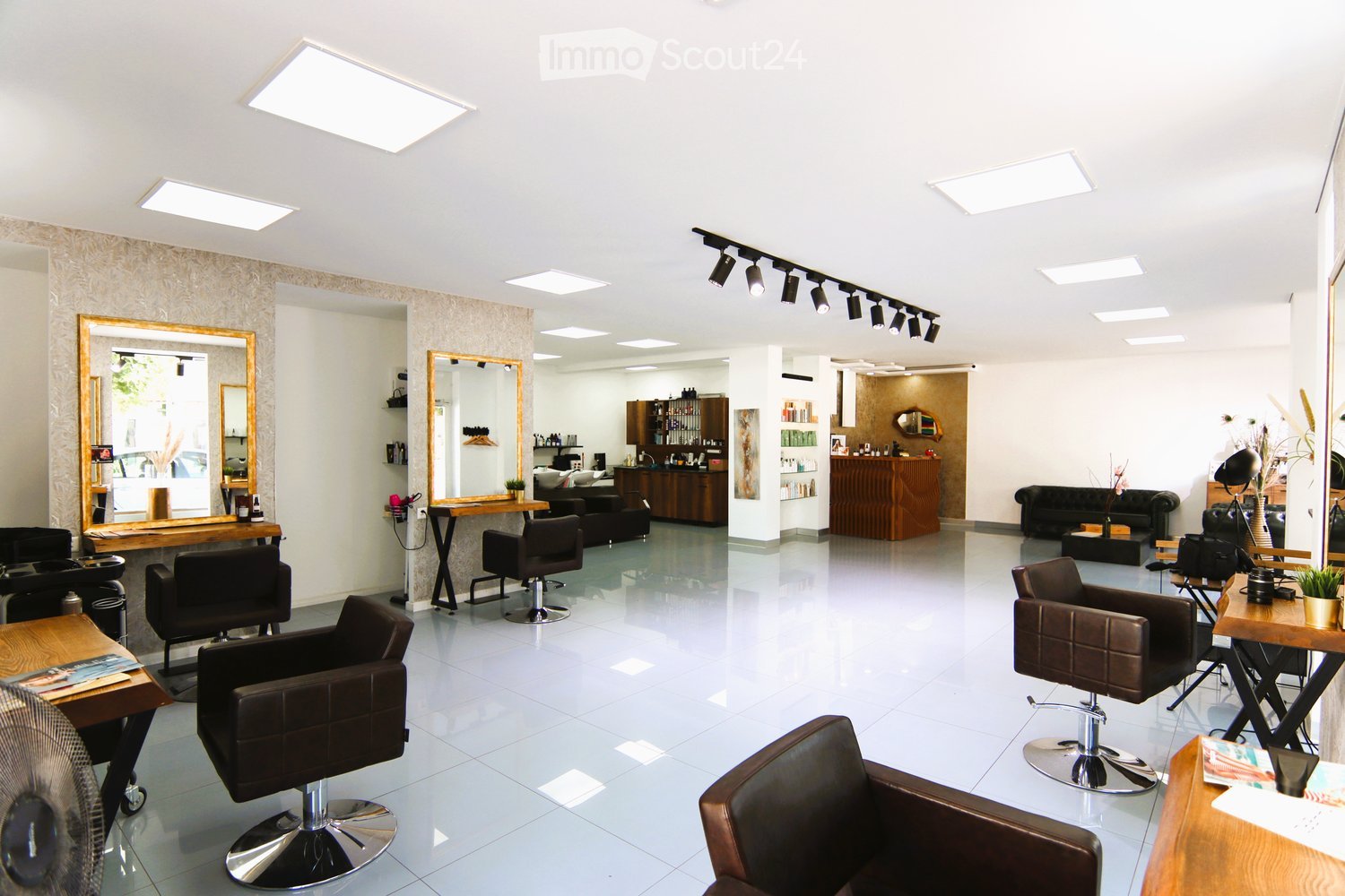 White tiled floor, white walls, modern lighting, chairs, mirrors, tables, shelves, fan, black leather furniture, wooden shelves, track lighting