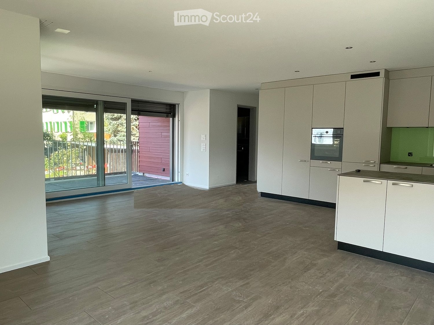 modern kitchen with white cabinets, large windows, balcony