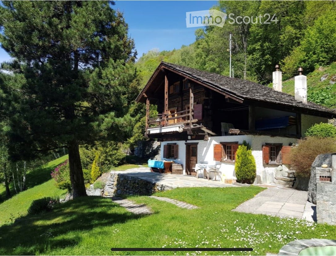 wooden facade, stone wall foundation, wooden balcony, chimneys, wooden door, grassy garden, stone walkway, trees