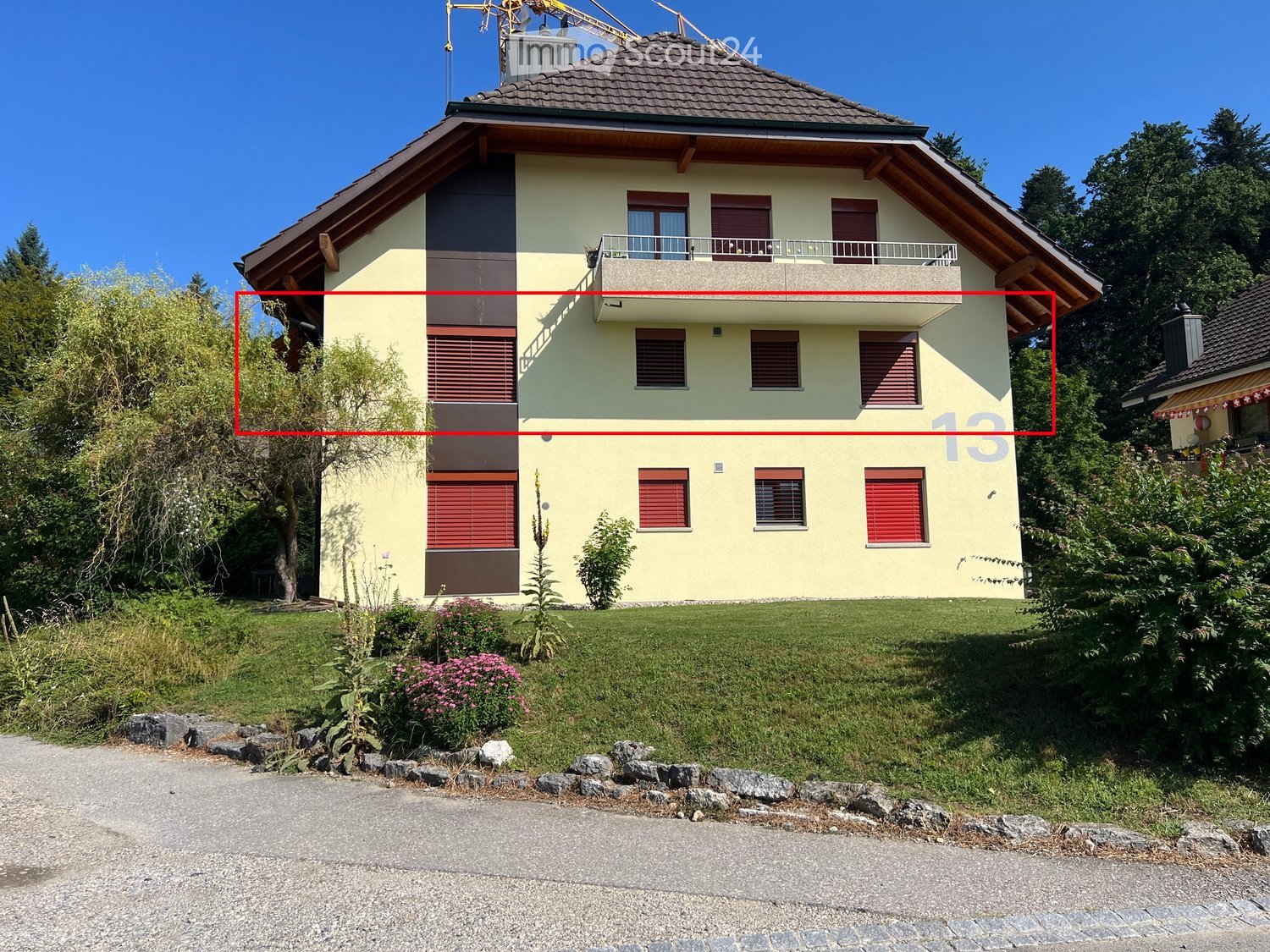 2 story house, beige paint, brown roof, red shutters, balcony on second floor