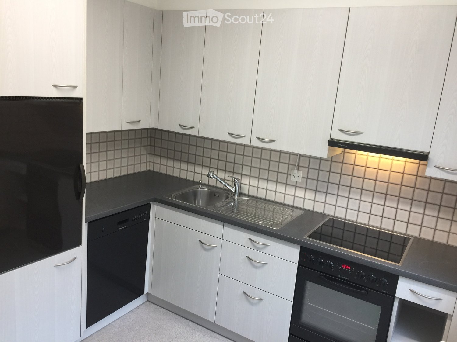 modern kitchen, white cabinets, grey countertops, integrated dishwasher and washing machine, gas stove, sink with faucet, tiled backsplash