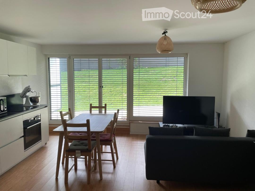 Dining area with a table, chairs, a microwave, kitchen appliances, couch, TV, large window