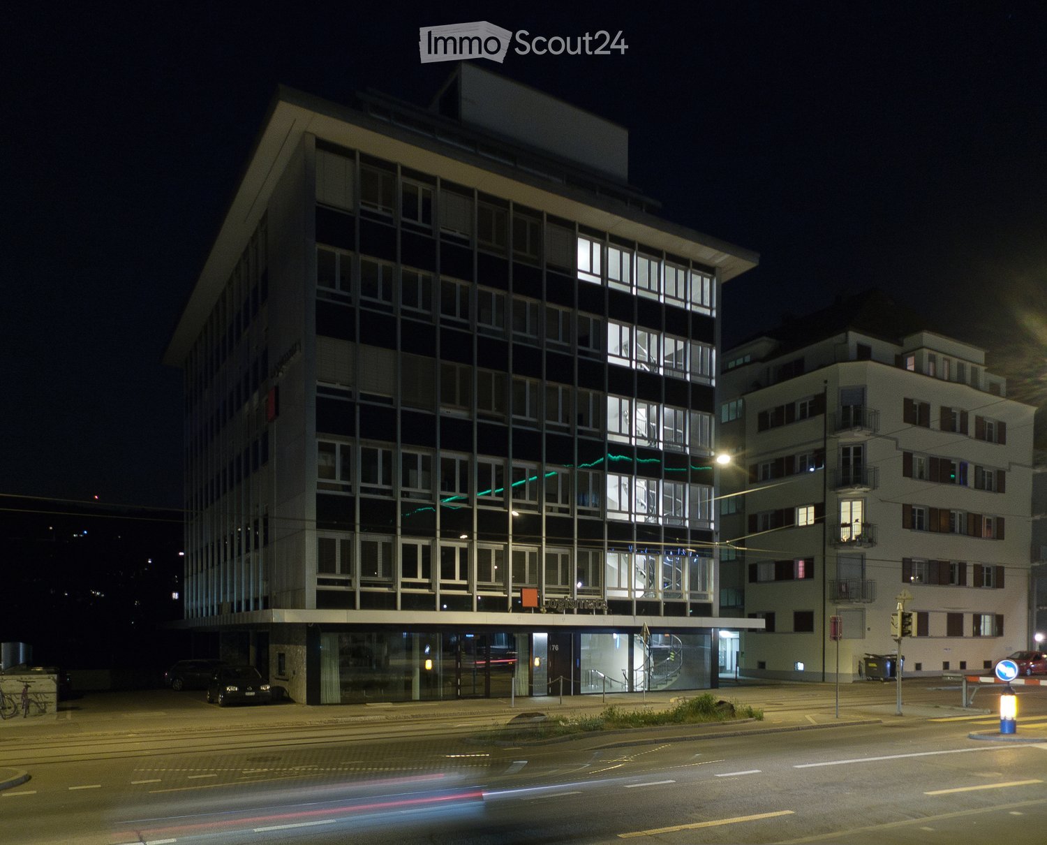 modern office building, glass walls, 4 stories, entrance on the left, illuminated windows