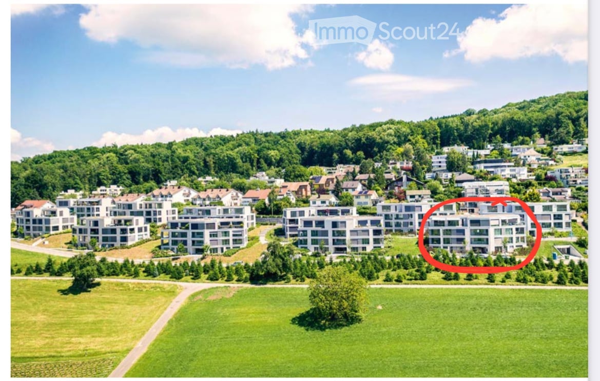 Building complex with several residential buildings, surrounded by a garden area, visible from afar, elevated, swimming pool
