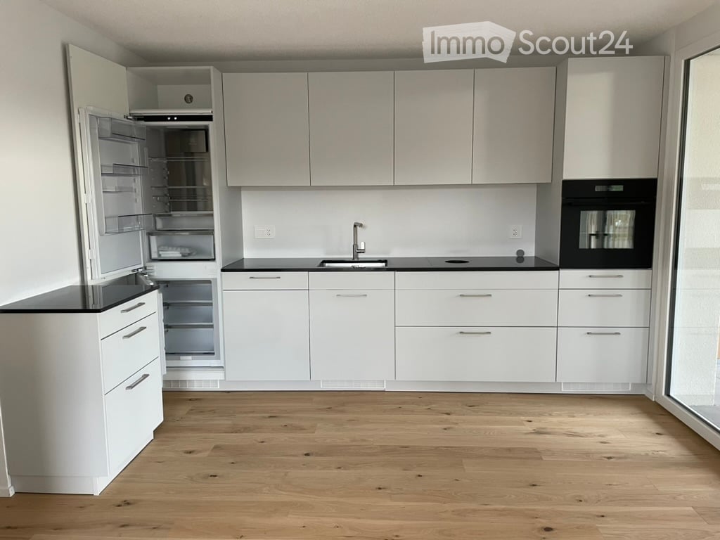 white kitchen, black countertops, stainless steel sink, open refrigerator, oven, dishwasher, wooden floor