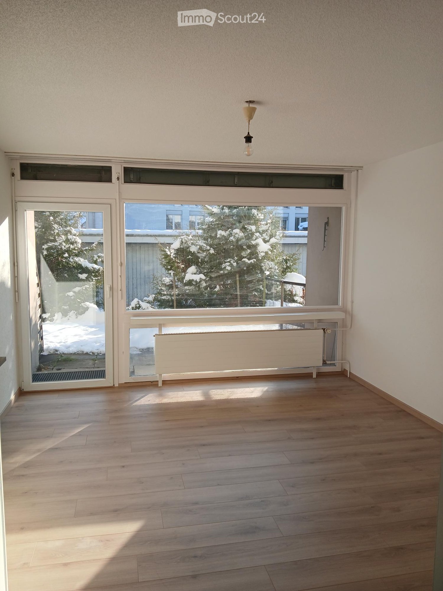 wooden floor, sliding doors, large windows, heater, natural light, white walls