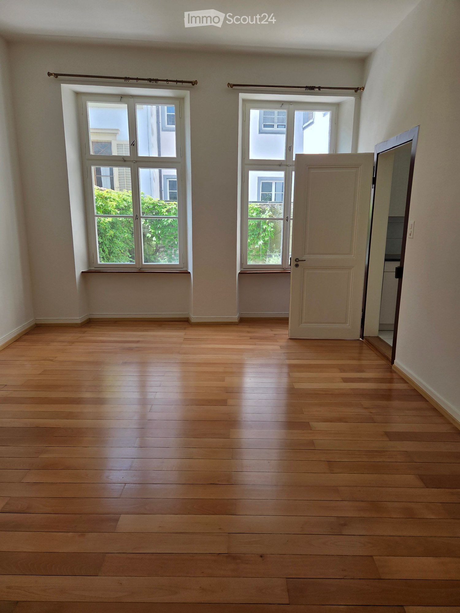 wooden floors, two windows, open doors