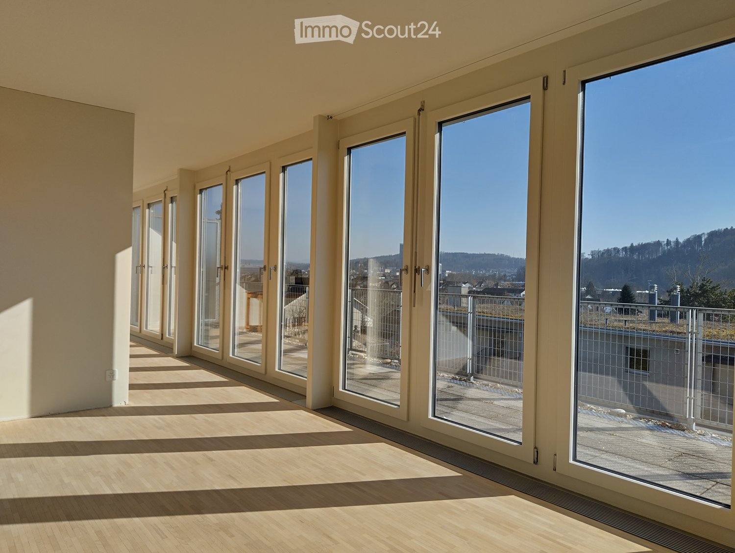 spacious room with sliding glass doors leading to a terrace, hardwood floors, and scenic views