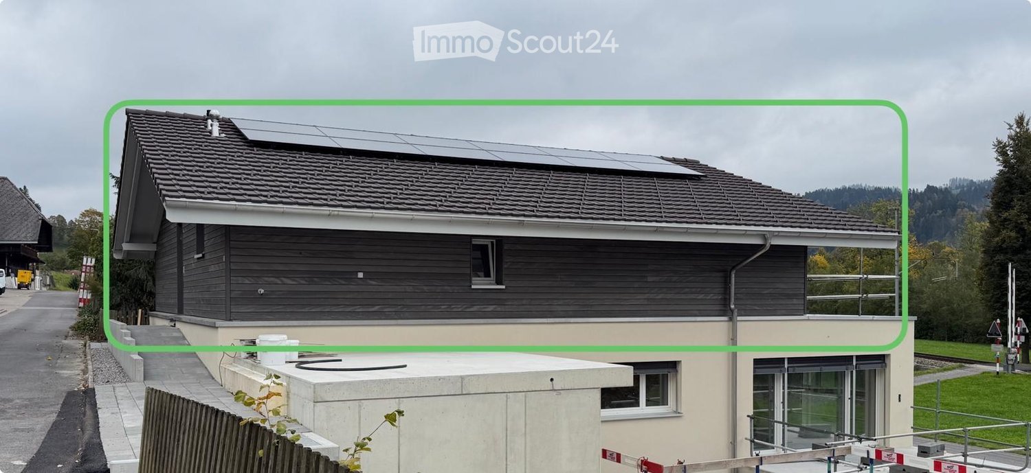 2 story house, solar panels on the roof, gray exterior, large windows, steps at entrance