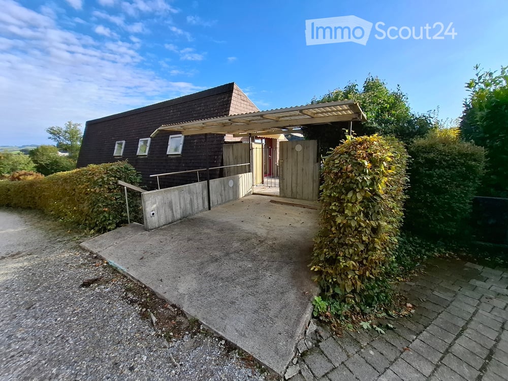 Single story detached house, dark brown roof, windows, wooden front door, concrete driveway