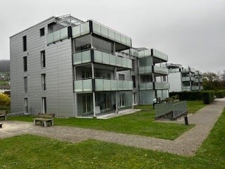 apartment building, large balconies, well-kept lawn, paved walkways, benches