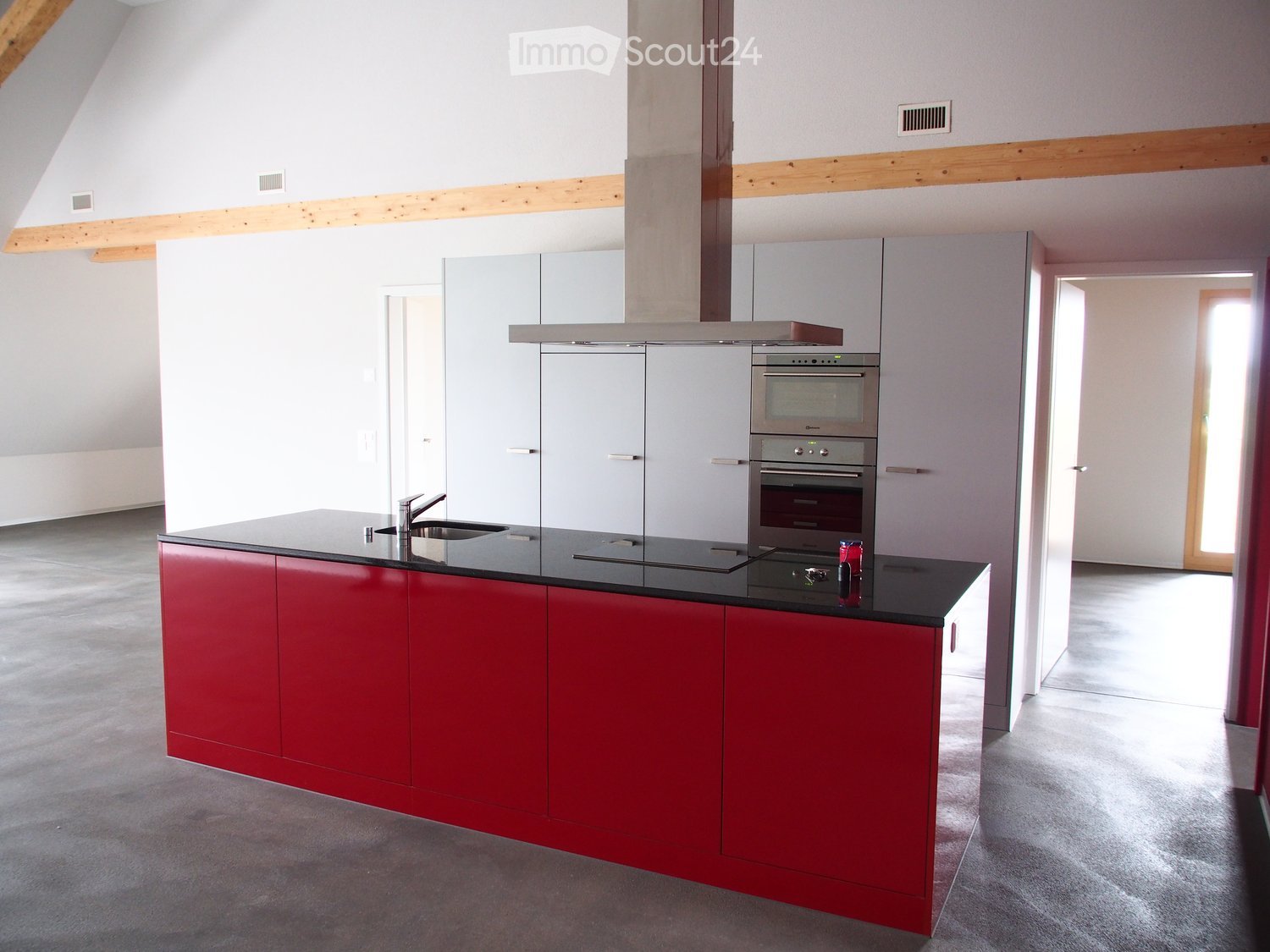 large open kitchen, red cabinets, black countertop, stainless steel hood, white cabinets, double oven, wooden beams