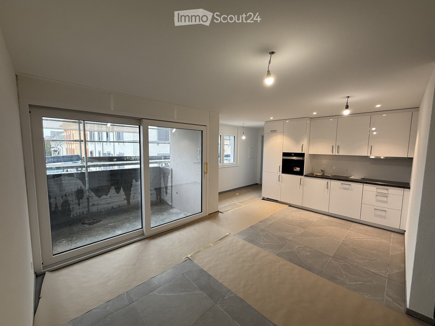 living room, open floor plan, kitchen, large sliding glass door, balcony, white cabinets, tiled floor