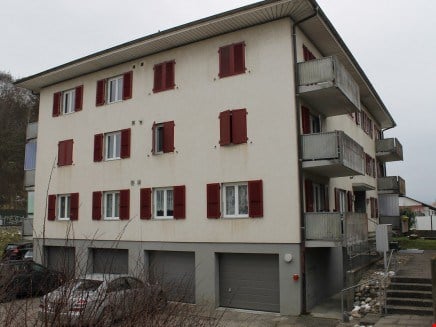 multistory building, white paint, red shutters, 2 garages, 6 apartments