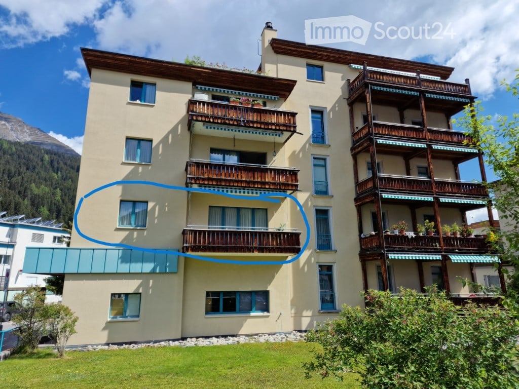 multi-story building, balconies, solar panels on the roof, wooden fence