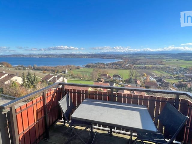 Balcony with table and chairs, view of the lake and mountains