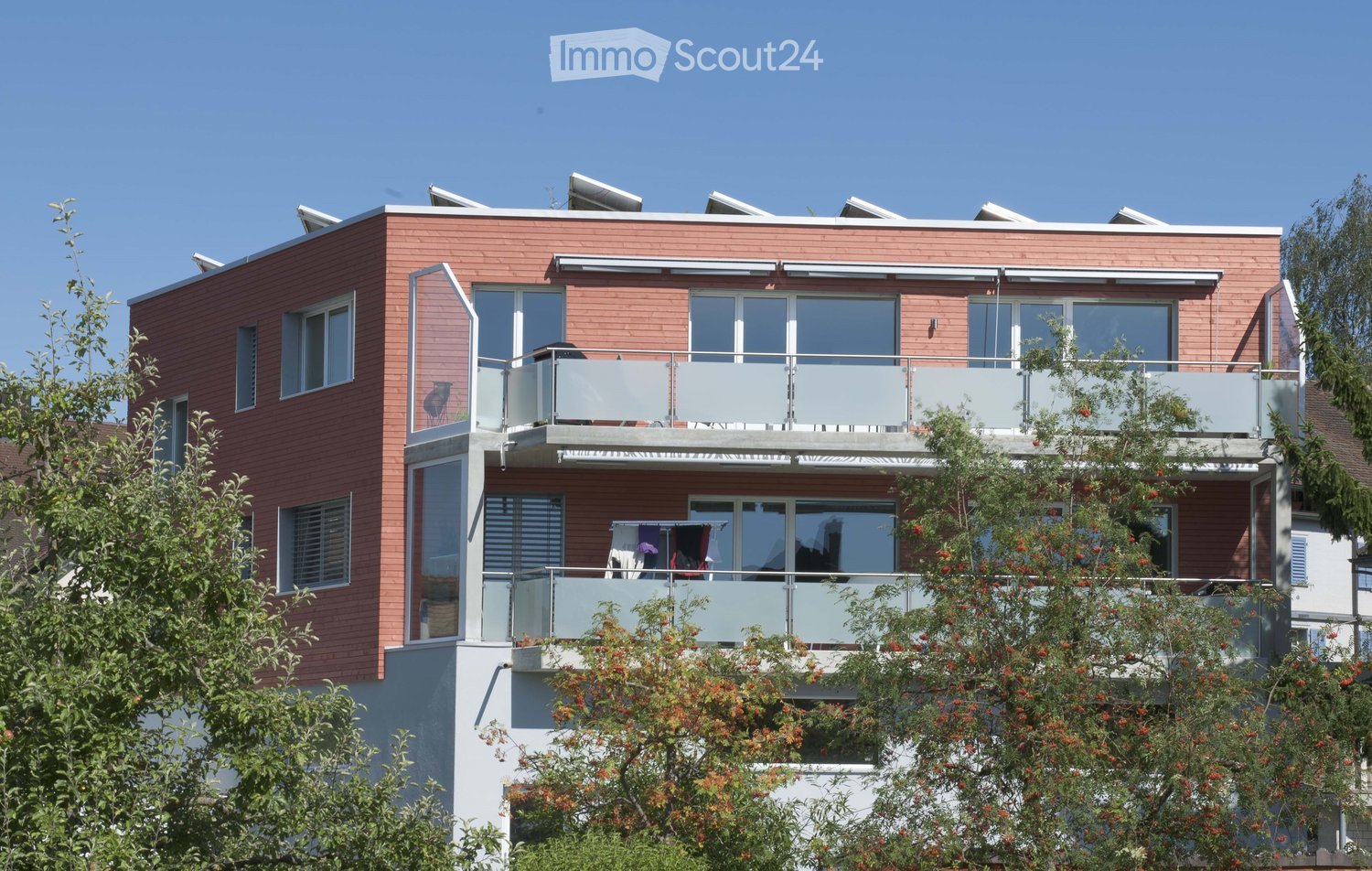modern architecture, brick facade, large glass windows, two-level balcony, solar panels on roof