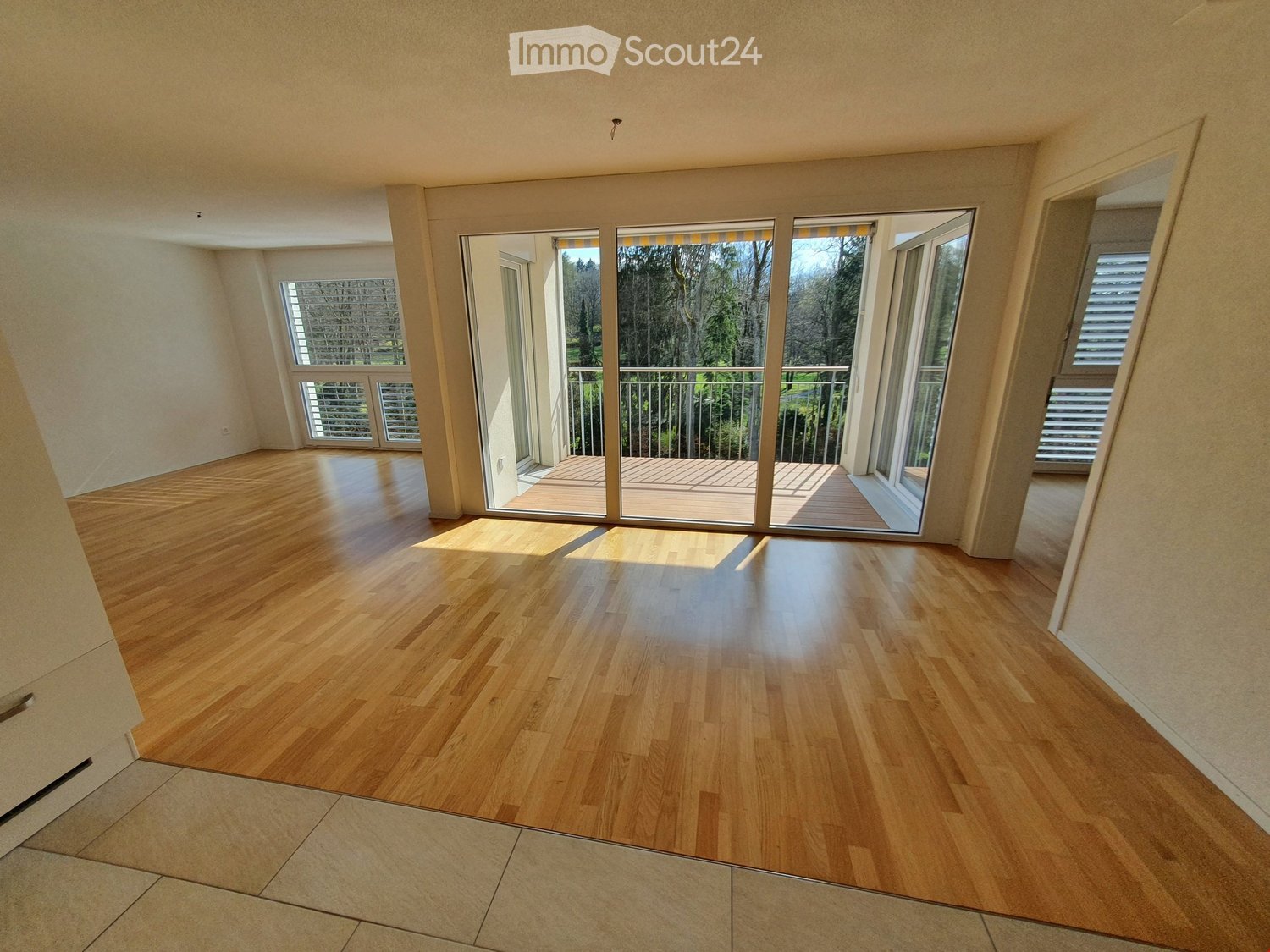 large windows, balcony, wooden floor, sliding glass doors
