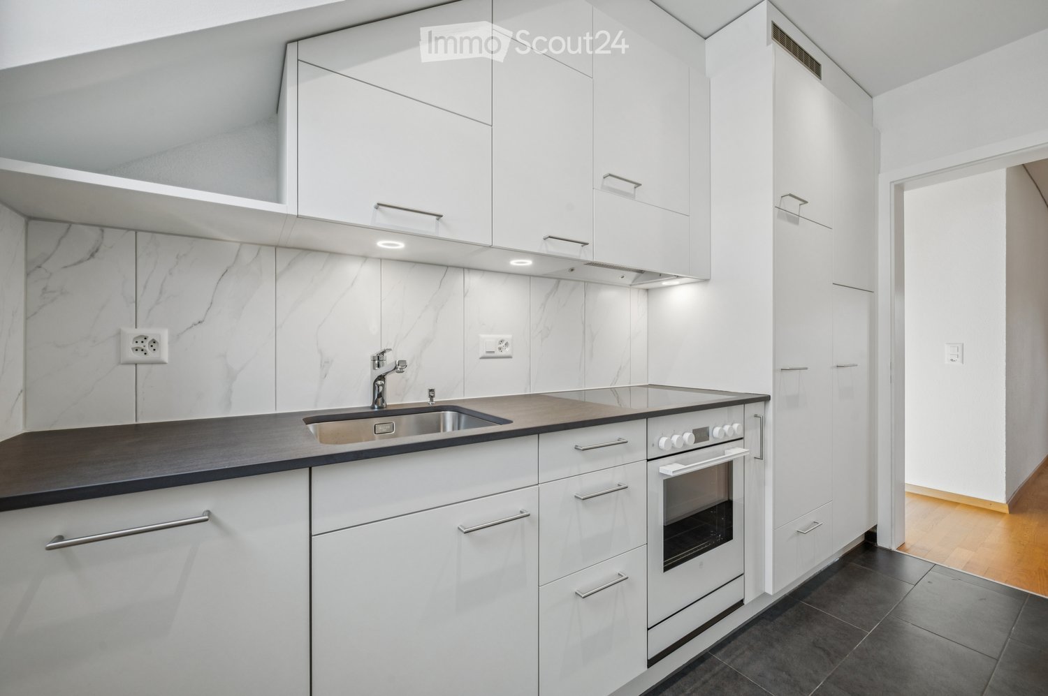 Kitchen with white cabinets, marble countertops, stainless steel sink, undermount sink, gas stove, electric oven