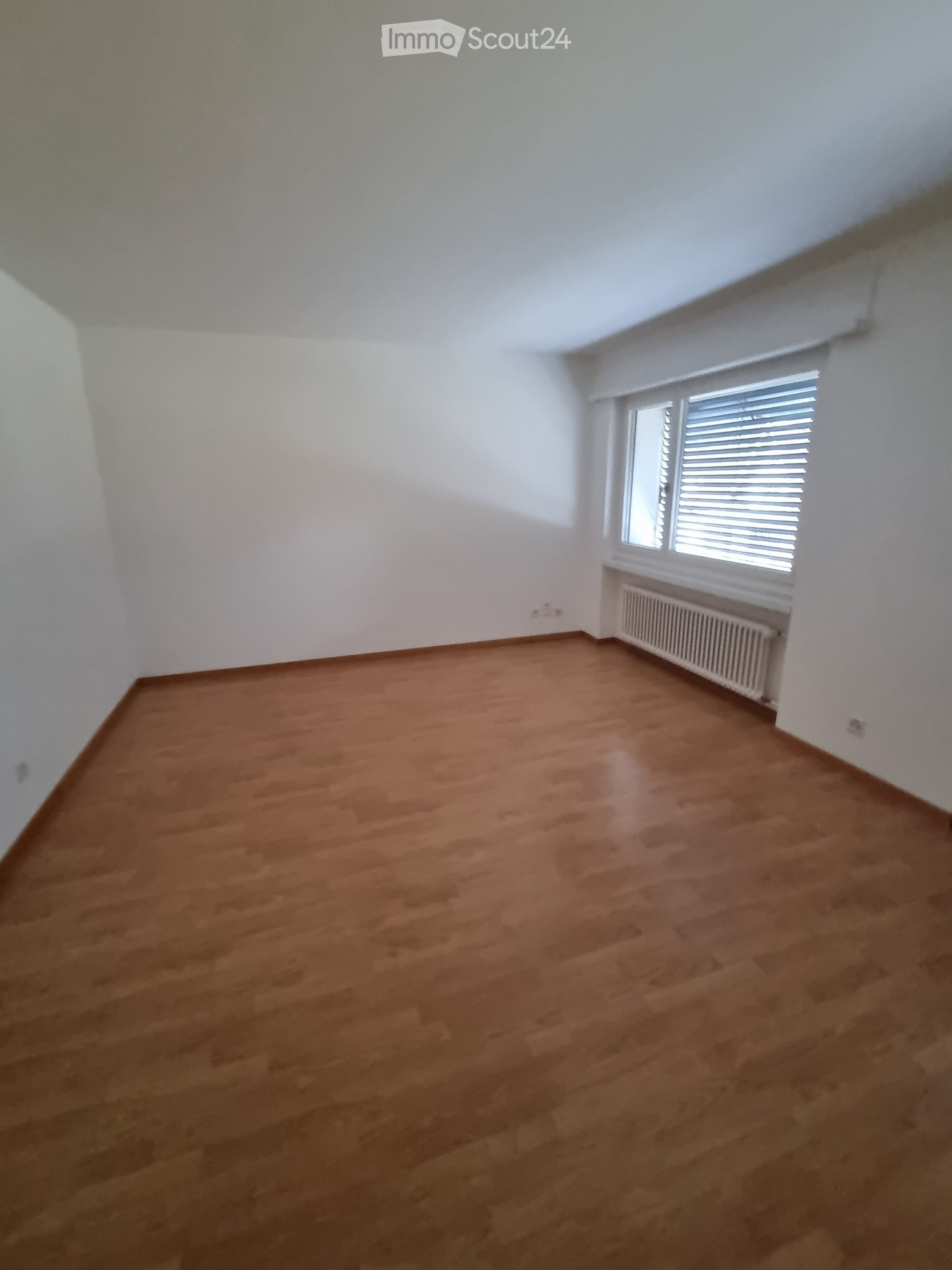 empty room, wooden floor, white walls, window with blinds, radiator