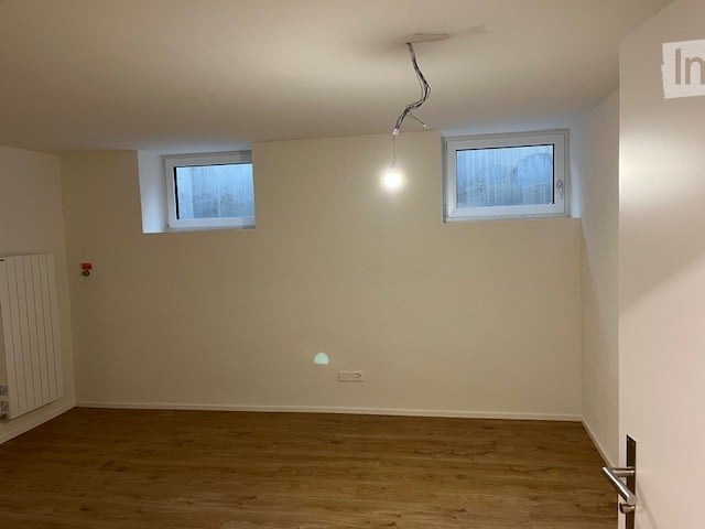 empty room, wooden floor, 2 windows, white walls, white ceiling, ceiling light, outlet