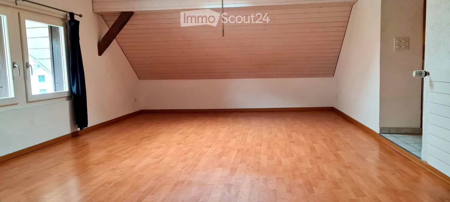 wooden floor, ceiling with wooden planks, two windows, two curtains, a power outlet.