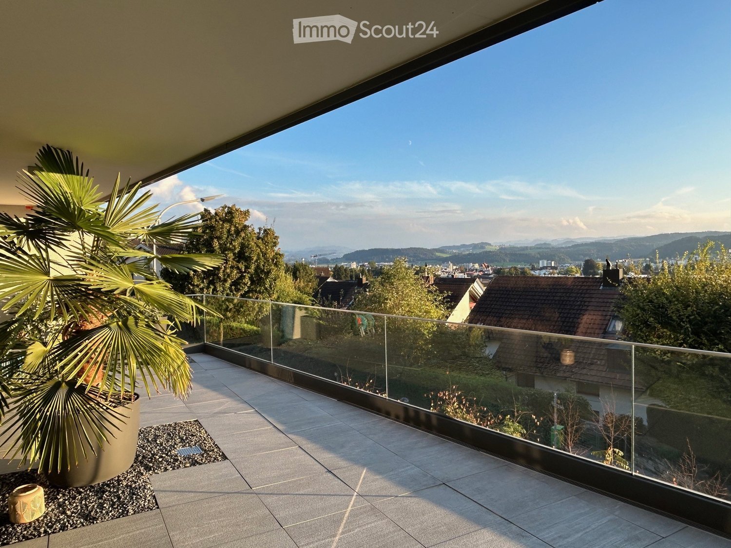 glass railing, tiled floor, outdoor potted plant, distant mountain view