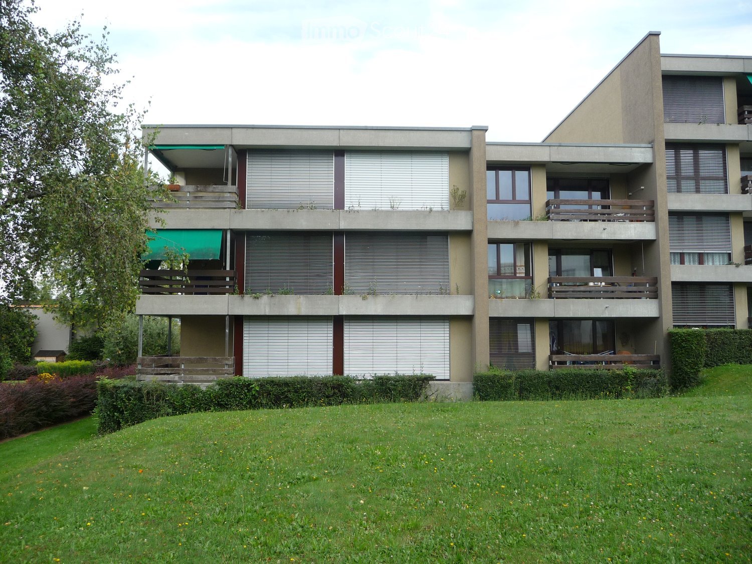 Multistory apartment building, concrete, multiple balconies, garden