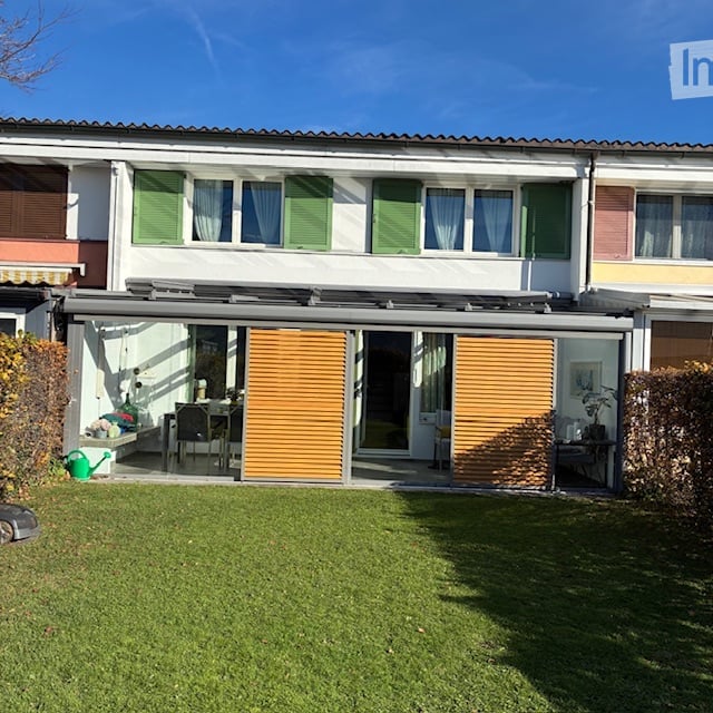 two story house, green shutters, terrace, large windows, well-manicured garden