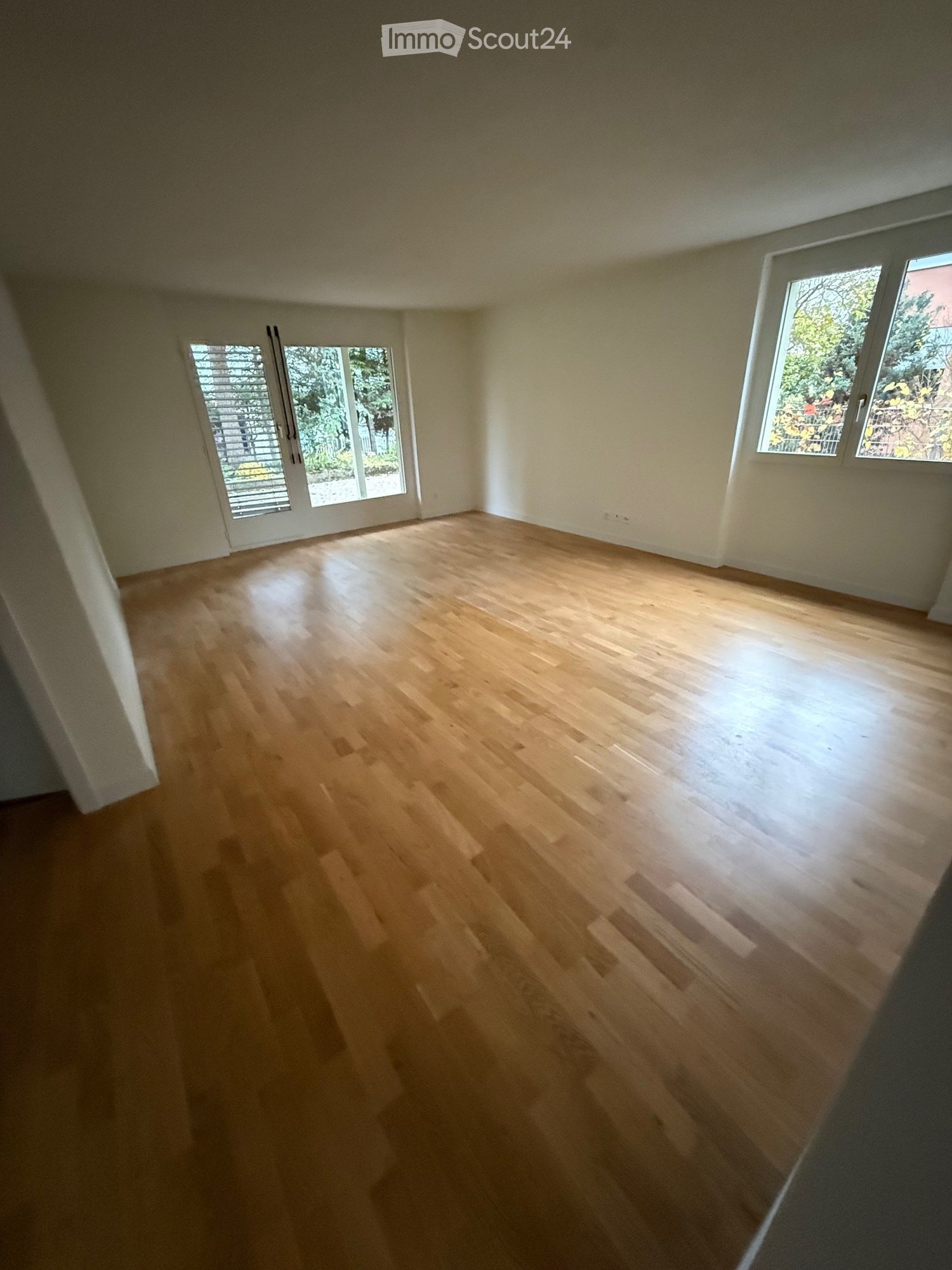 Empty room, wooden floor, large windows, sliding doors