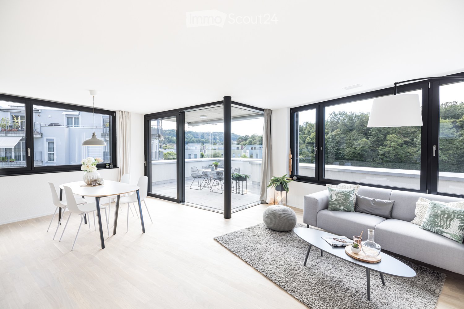 open-plan living and dining area with a balcony, floor-to-ceiling windows, modern furnishings, white walls, wooden floors, natural light