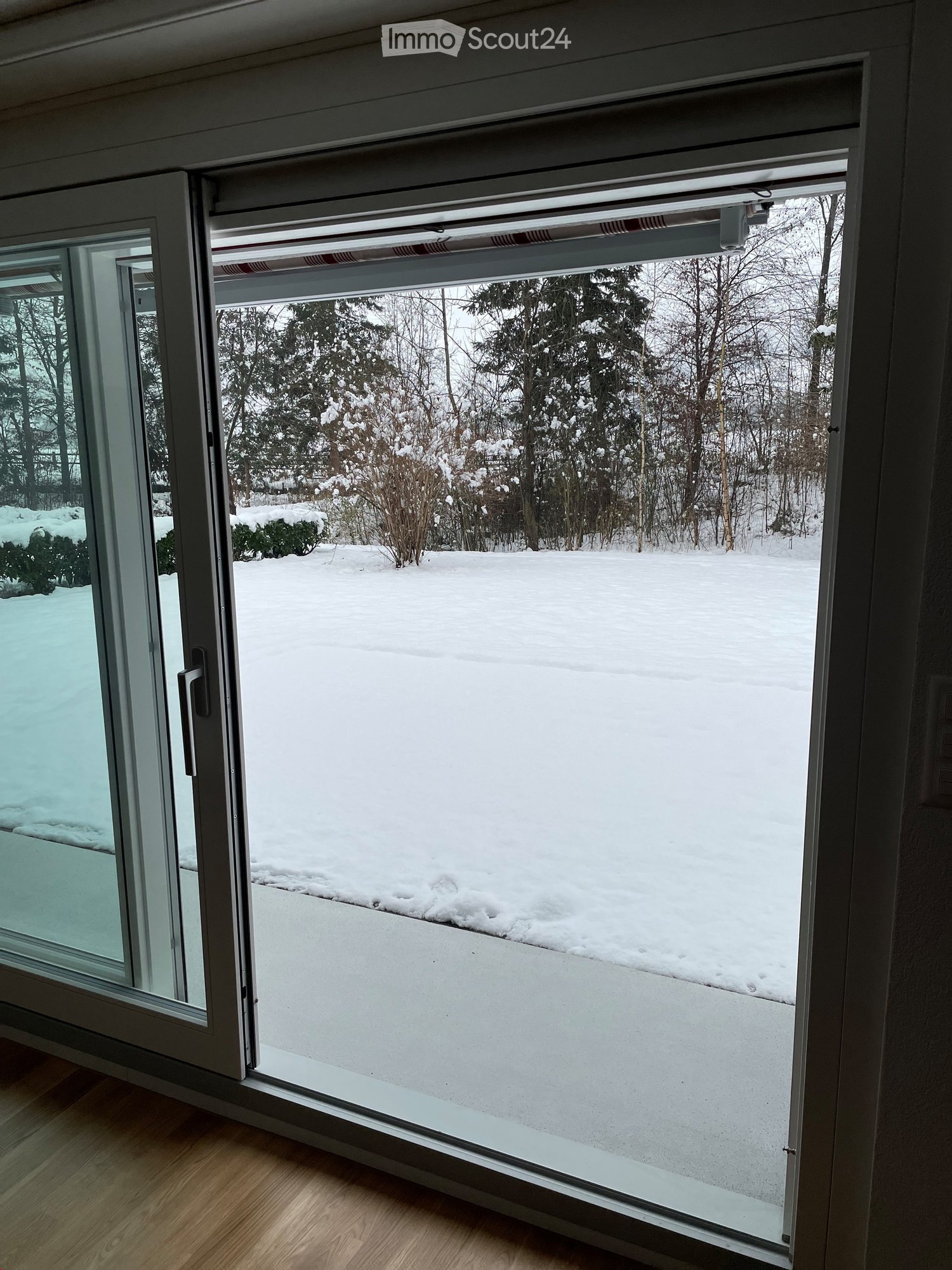 sliding window, wooden floor, balcony with snow covered ground and trees