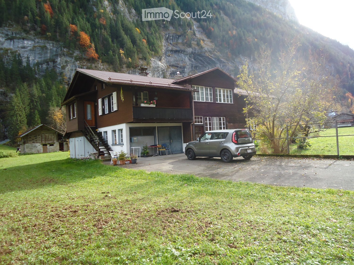 2 story house, brown walls, white windows, garage, green lawn, mountain view, car parked