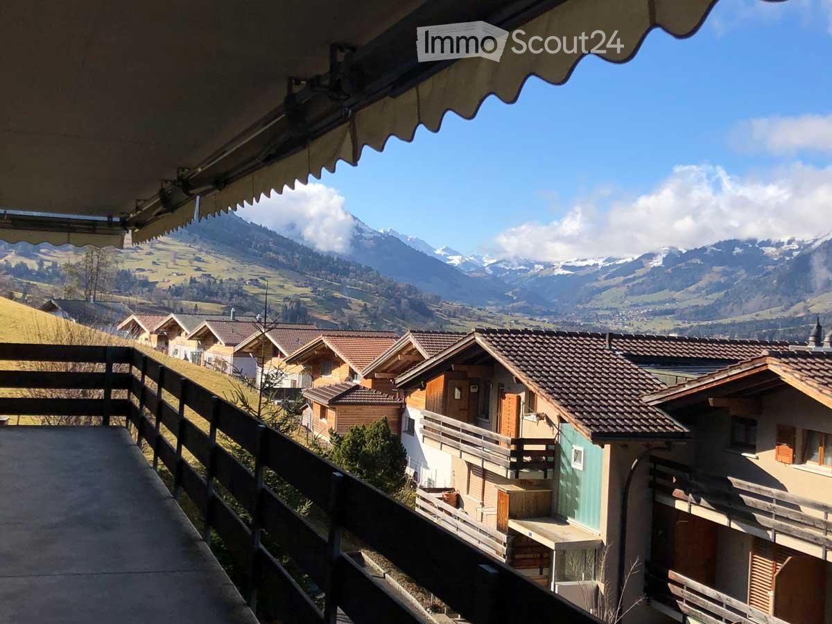 Outdoor wooden railings, concrete balcony, open view of surrounding mountains