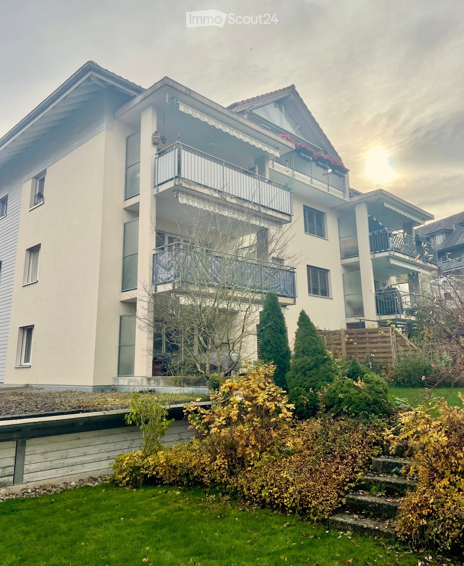 White 3 story building, balcony, multiple windows, brick chimney, garden
