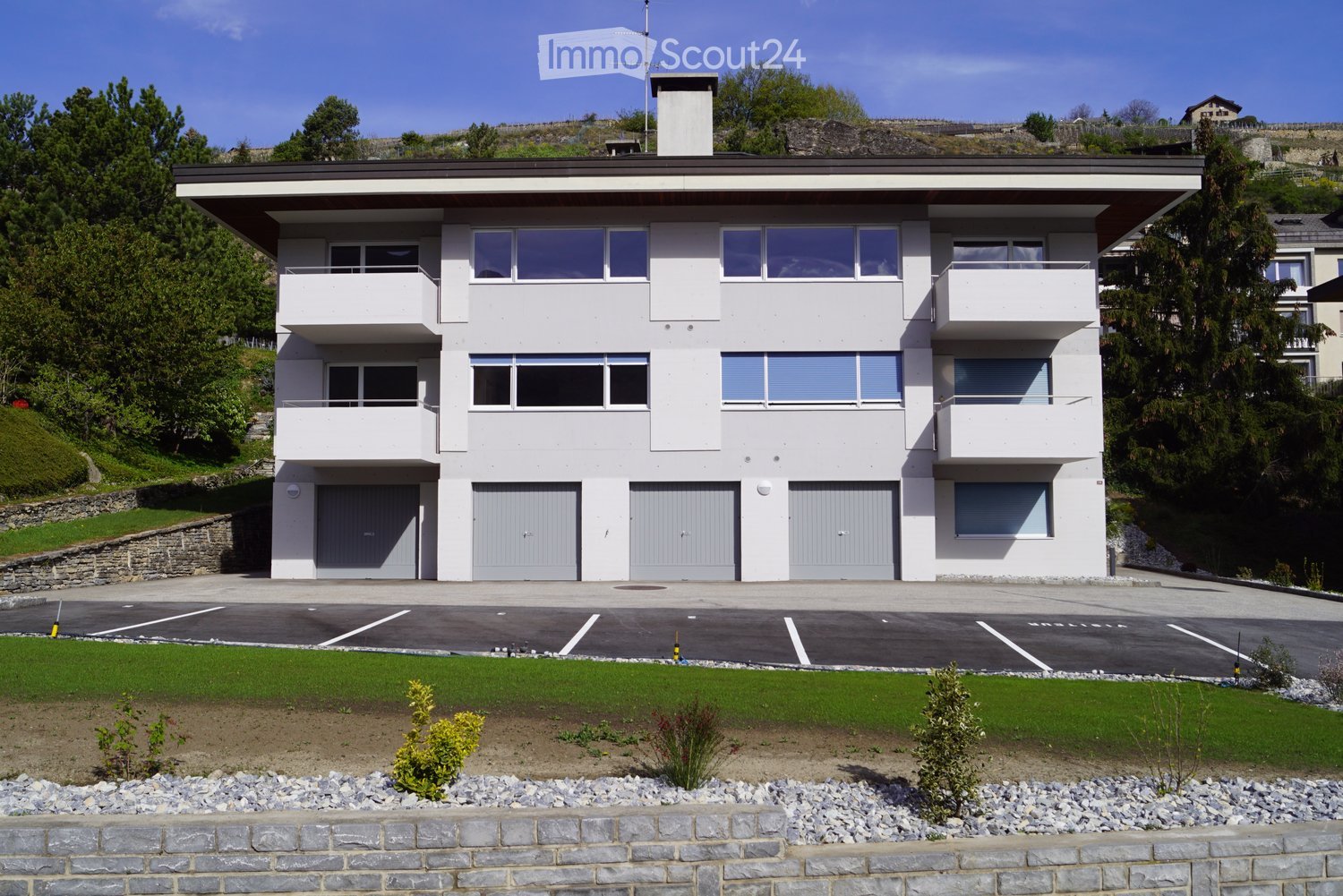 modern 2 story house, white facade, grey garage doors, balconies, parking in front