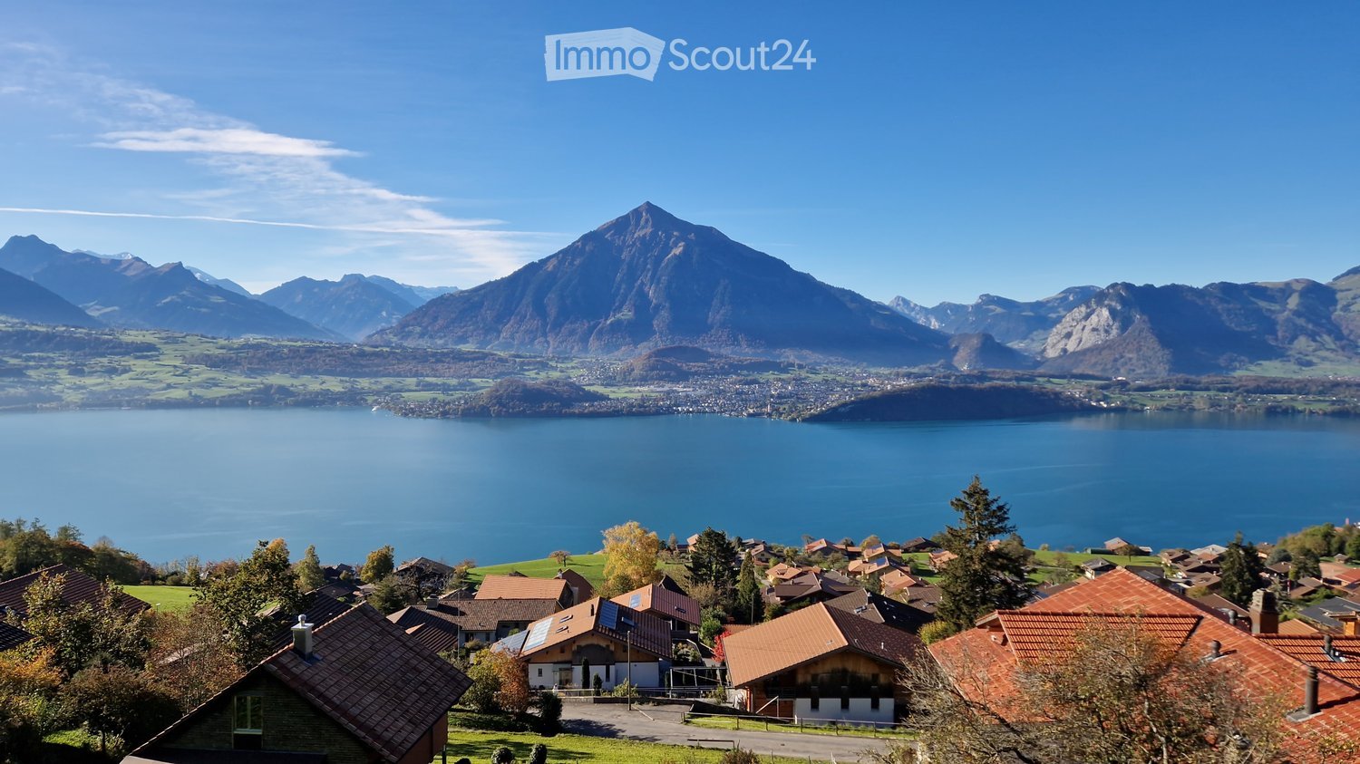 Mountain scenery, several houses, solar panels, lake