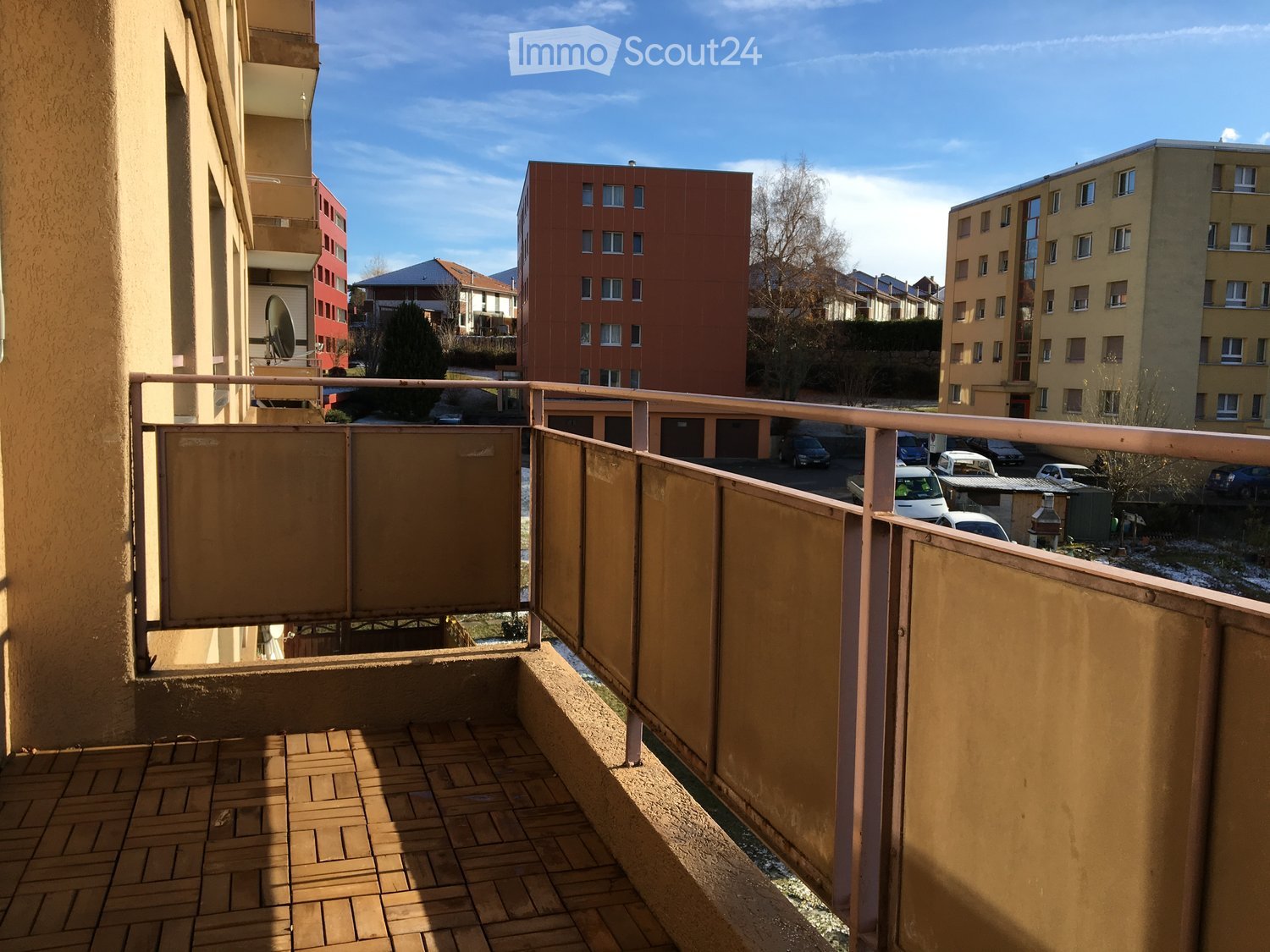 tiled floor, metal railing, covered, overlooking the parking area and surrounding buildings