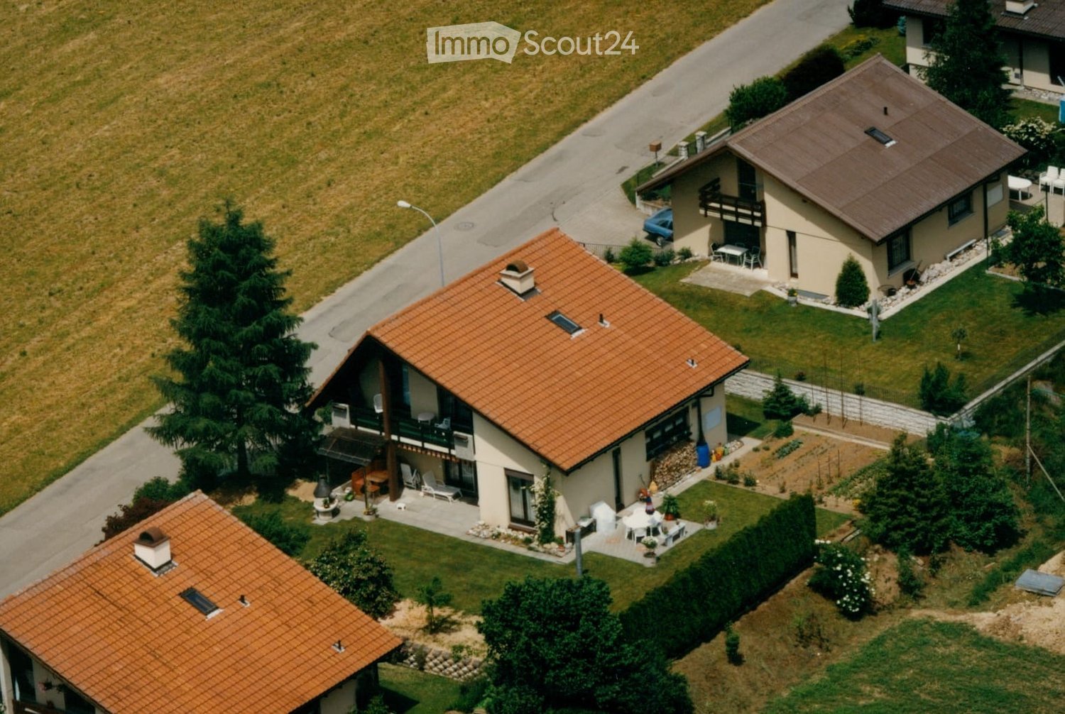 3 story house, red roofs, balconies, large front garden, greenery around