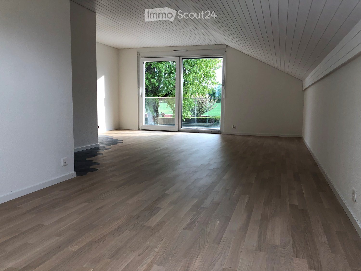Empty room with glass sliding doors leading to an outdoor view.