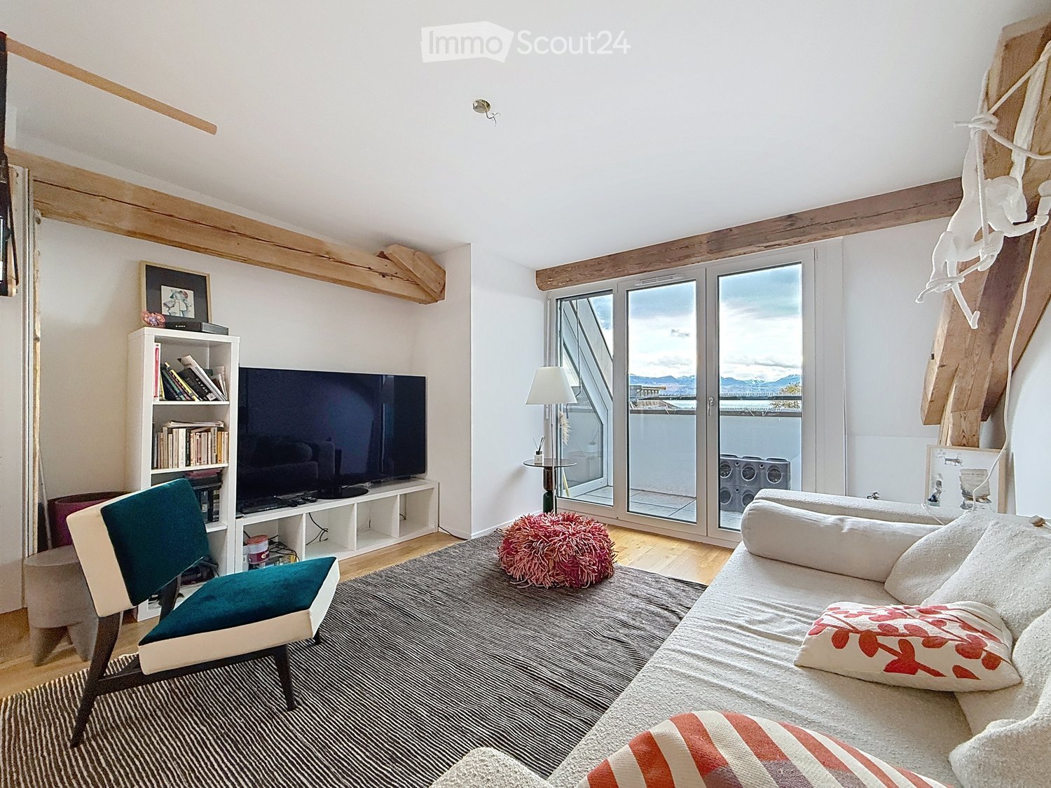 sofa, pillows, coffee table, floor lamp, TV, bookcase, rug, chair, balcony with glass door, wooden beams