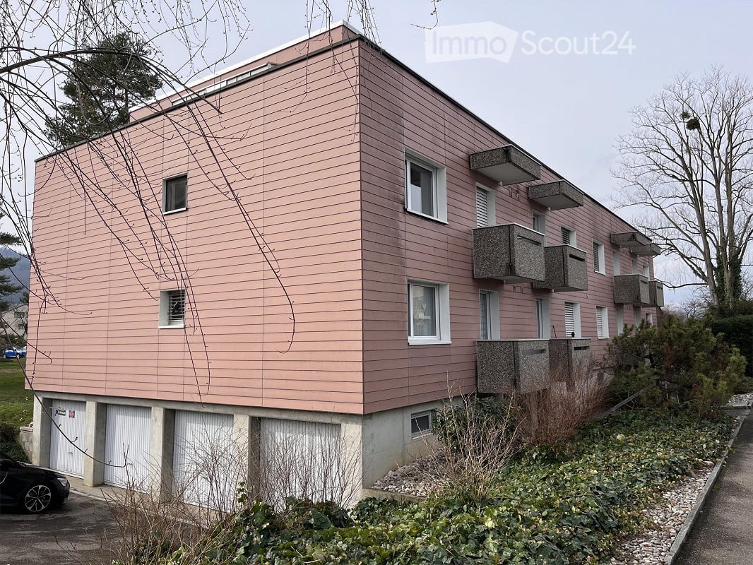 2 story apartment building, pink exterior, white garages, balconies, white windows