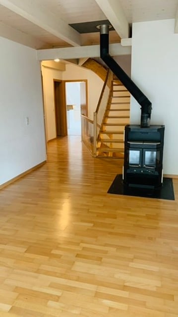 open space, fireplace, hardwood floors, wood stairs, wall outlets