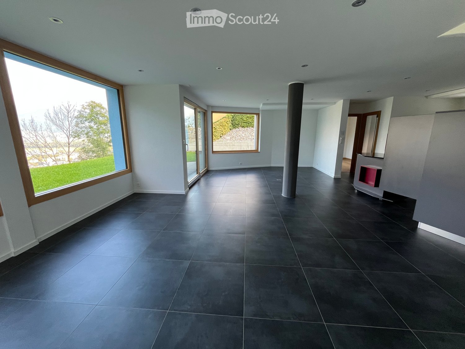 large windows, modern interior, black tiles, sliding glass doors, white walls, central column