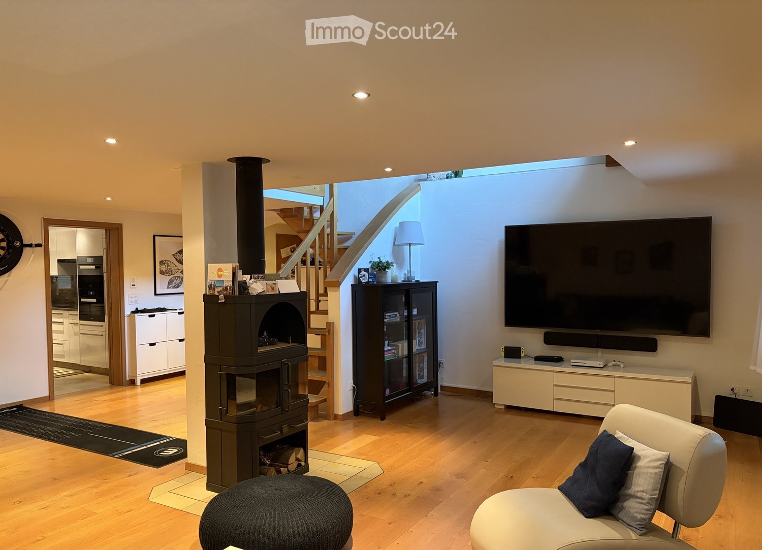 fireplace, large TV, wooden floor, couch, armchair, cabinet, entertainment center, shelves