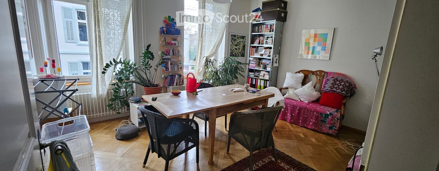 wooden table, chairs, sofa, bookshelves, plants, lamp