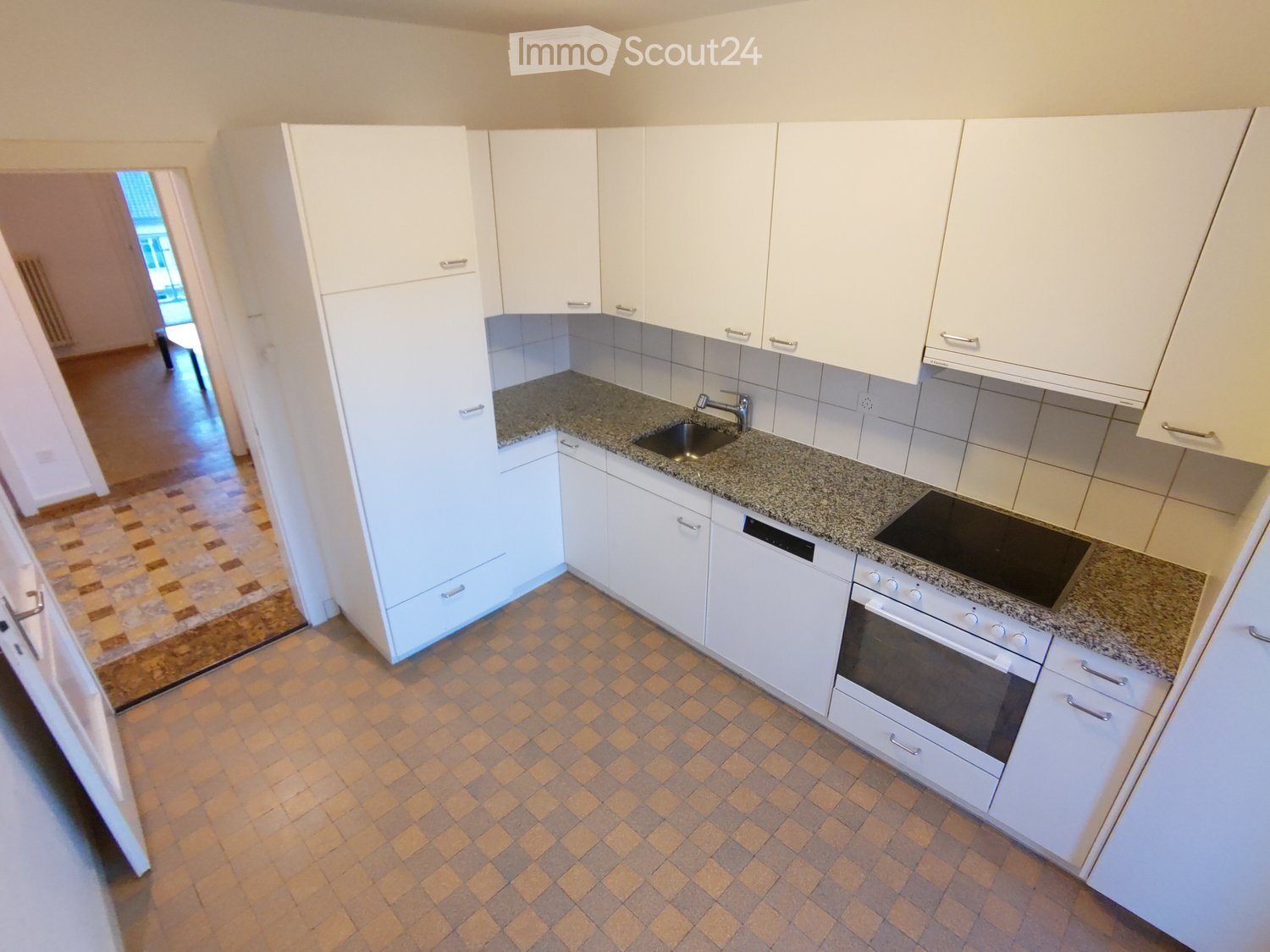 Modern kitchen with white cabinets, granite countertop, built-in oven, sink with faucet, tiled floor