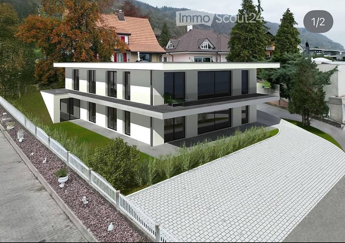Contemporary style house, with large glass windows, white and grey exterior, two floors, balcony
